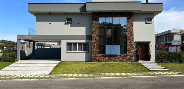 Fachada de casa de esquina preta e cinza com concreto e alumínio